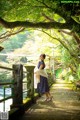 A woman in a polka dot dress standing on a bridge.