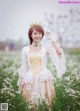 A woman wearing a crown standing in a field of flowers.