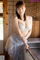 A woman in a white lingerie posing in a kitchen.