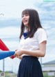 A woman in a school uniform holding a red and blue baton.