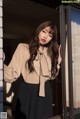 A woman standing in front of a glass door.