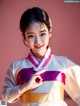 A woman in a white and pink hanbok posing for a picture.