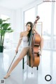 A woman sitting on a chair holding a cello.