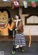 A woman riding a scooter in front of a graffiti covered wall.