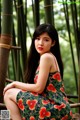 A woman in a green dress sitting on a wooden fence.